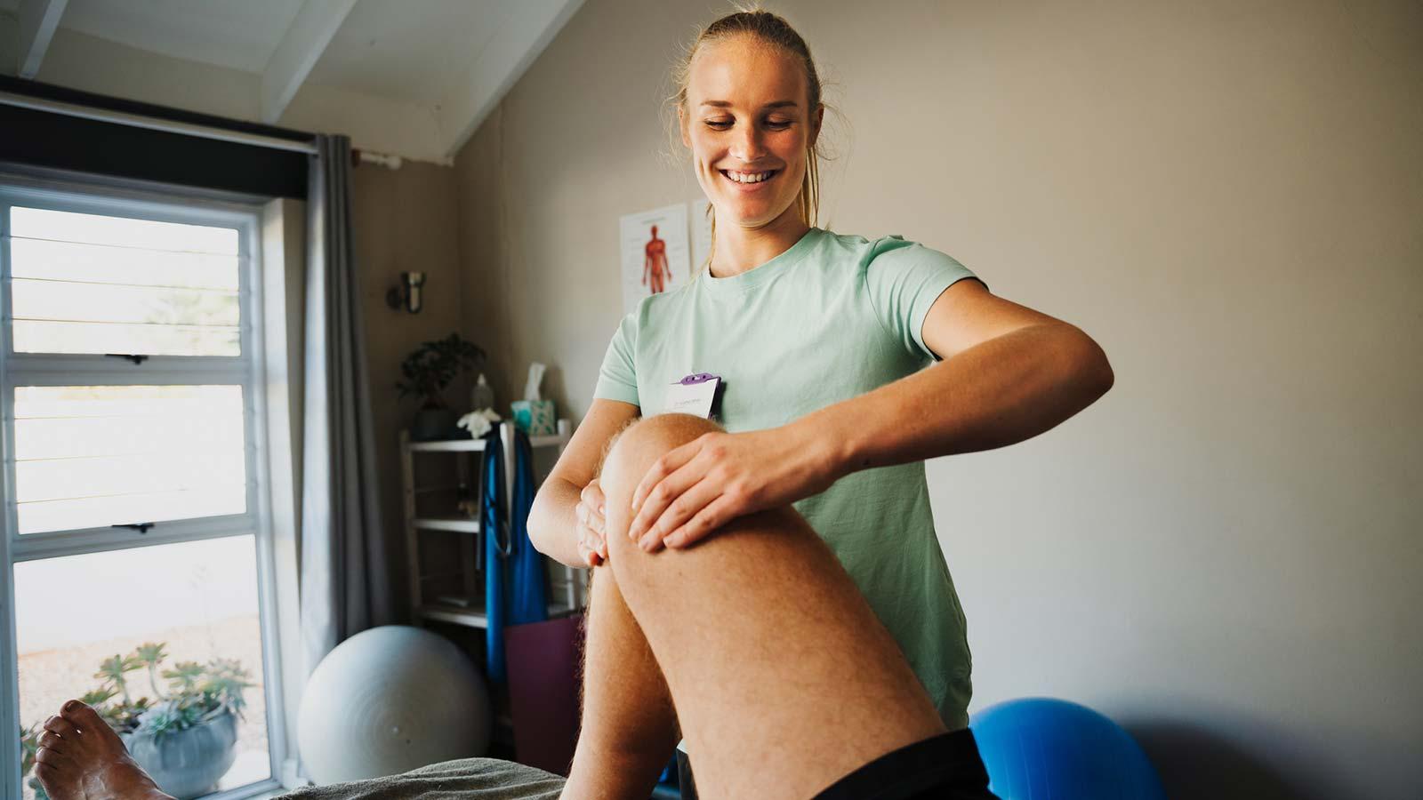 Physiotherapist working on patients knee