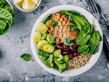 A bowl of chicken, vegetables, grains and legumes