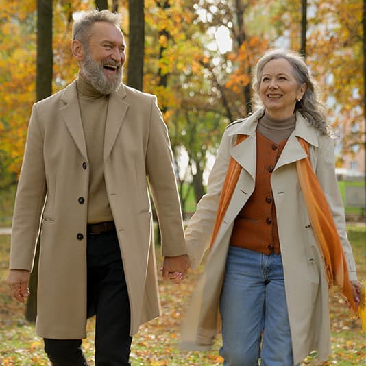 Happy couple holding hands walking in woods