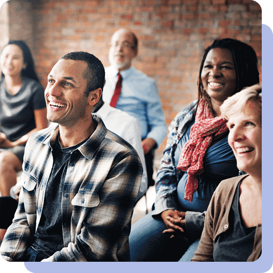 People sitting in an audience and smiling