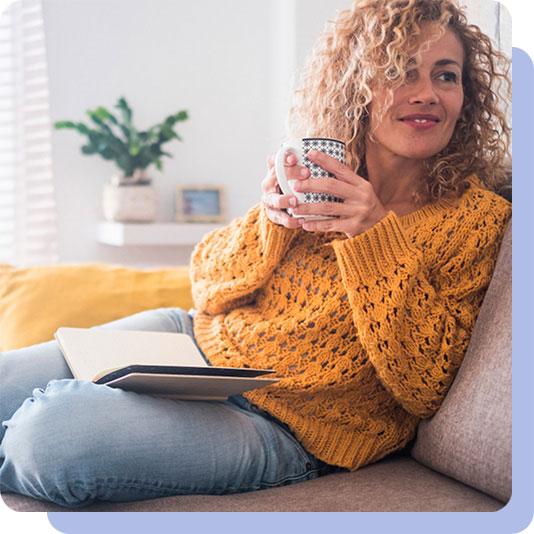 Woman on sofa holding mug