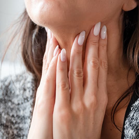 A woman examining her neck using her hand