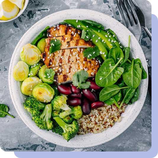 A bowl of chicken, vegetables, grains and legumes