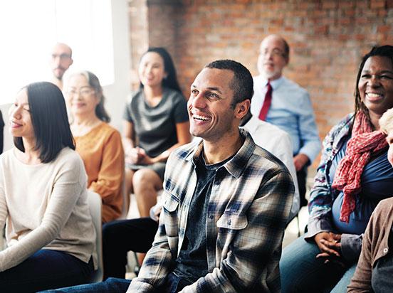 People sitting in an audience and smiling