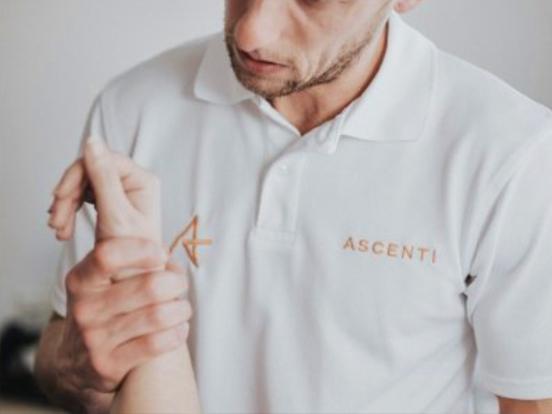 Ascenti physiotherapist examining patient's wrist