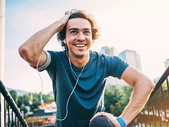 Man kneeling and smiling after a run