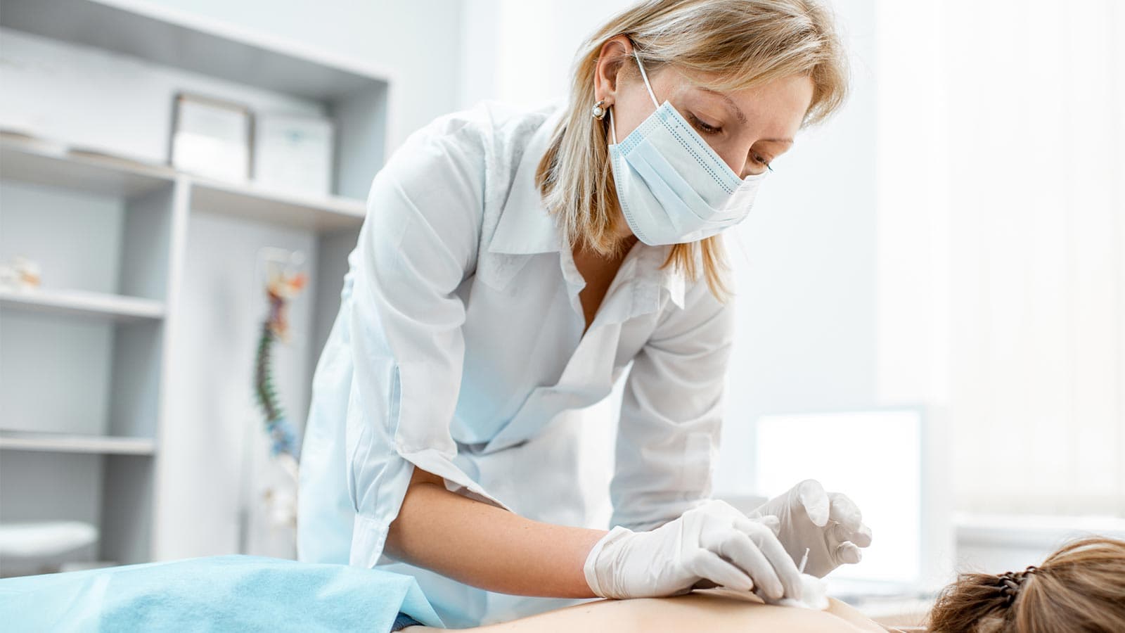 Acupuncturist and a patient during acupuncture treatment