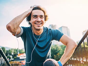 Man wearing earphones and resting during a run